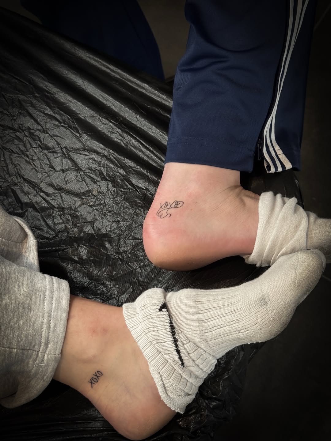 Feines XOXO Schriftzug-Tattoo am Knöchel